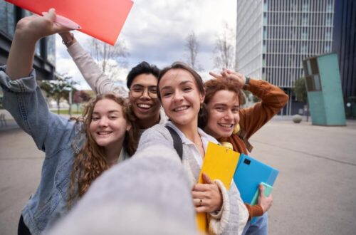 Des étudiants de fac multiraciaux prenant un selfie.