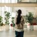 Jeune étudiante marchant dans un bâtiment universitaire ou collégial moderne, portant un sac à dos, représentant l'éducation et les nouveaux débuts.